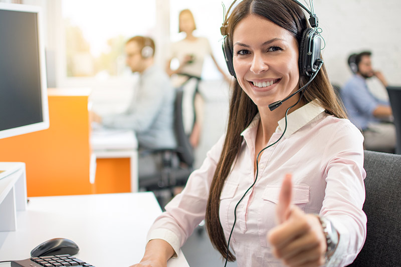 woman with headset showing thumbs up gesture